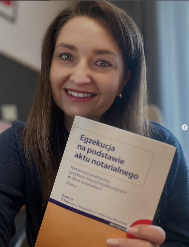 dr Urszula Gęślicka trzymająca publikację „Egzekucja na podstawie aktu notarialnego” wydawnictwa C.H. Beck